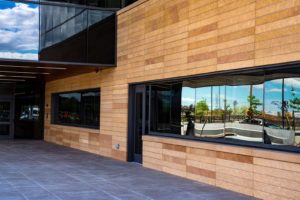 the side of the modern-looking BioFire building with long horizontal gypsum board tiles