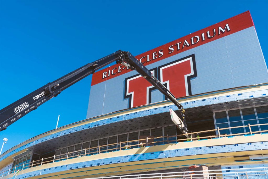 University of Utah stadium with a crane arm lifting insulation boards into place